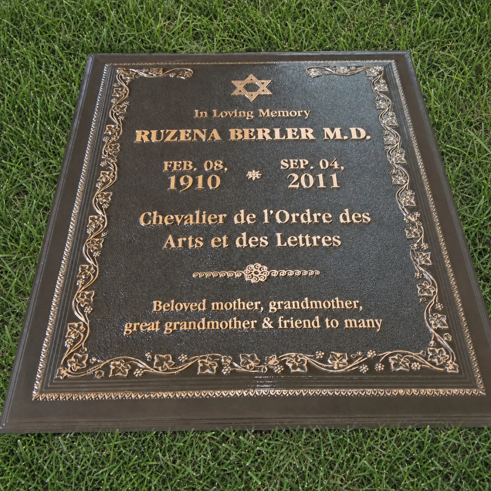 Custom bronze grave marker with raised lettering and floral border