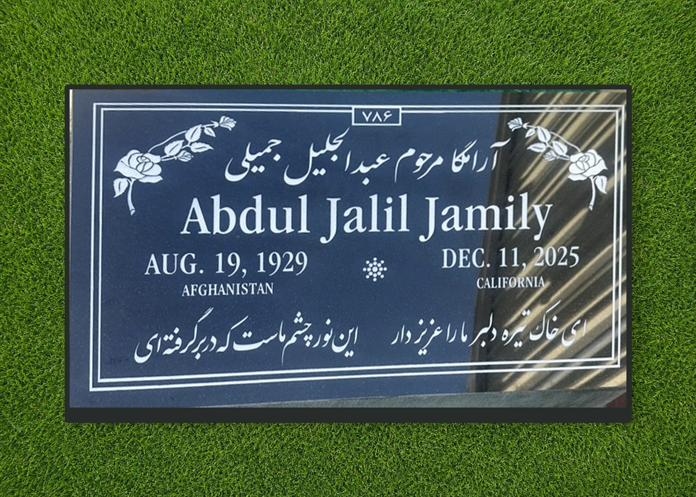 Custom black granite flat grave marker with multilingual floral design