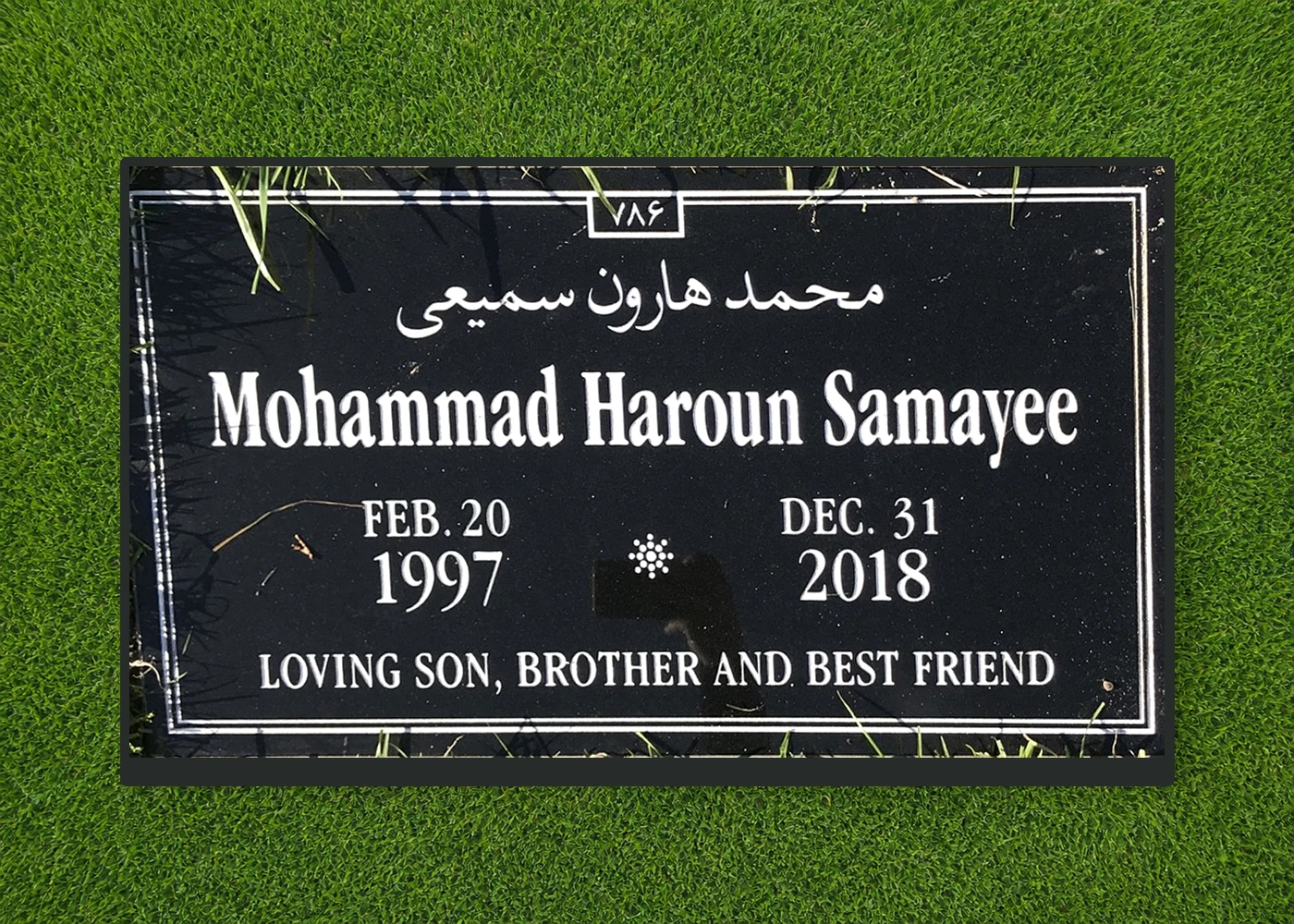 Black granite multilingual headstone with Arabic and English lettering