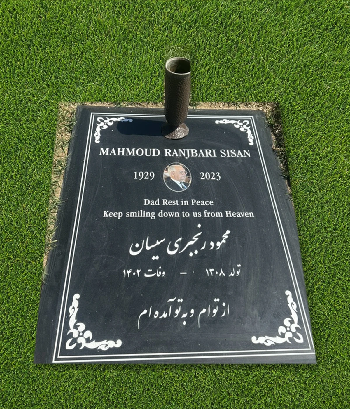 Black granite 39 by 30 inch half ledger with portrait, Persian lettering, and cemetery vase